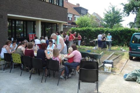 Zaterdag 27 juni, meer dan veertig vrijwilligers eten op de parking achter het nieuwe gebouw.