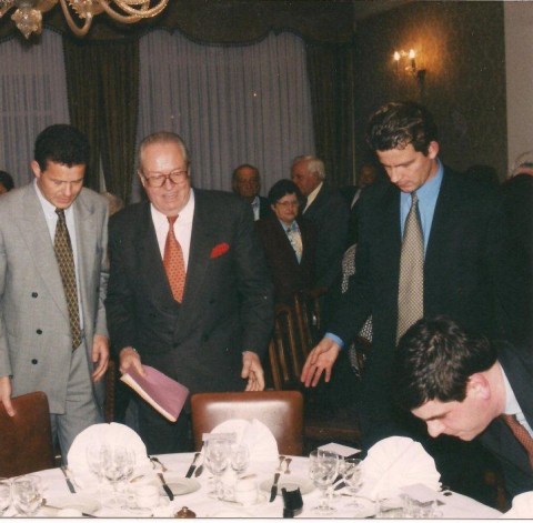 Na afloop van de spreekbeurt leiden VNDK-voorzitter Koen Dillen (rechts) en VB-voorzitter Frank Van Hecke (links) genodigde Jean-Marie Le Pen naar de eretafel. Filip Dewinter schuift mee aan.